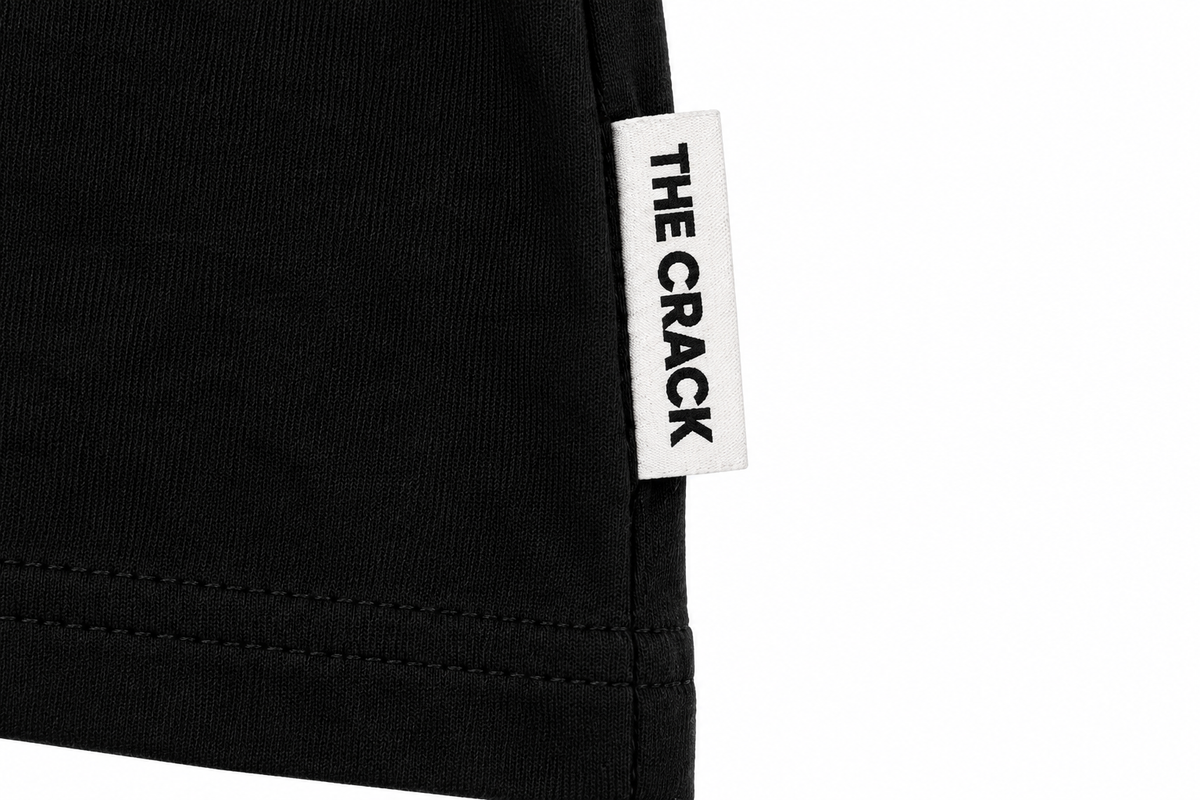 Detalle de etiqueta lateral THE CRACK en Crop Top mujer negro